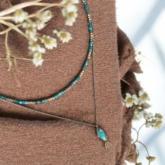 Azure Silver Fish and Apatite Gemstone Necklace Set displayed on soft fabric with floral accents.