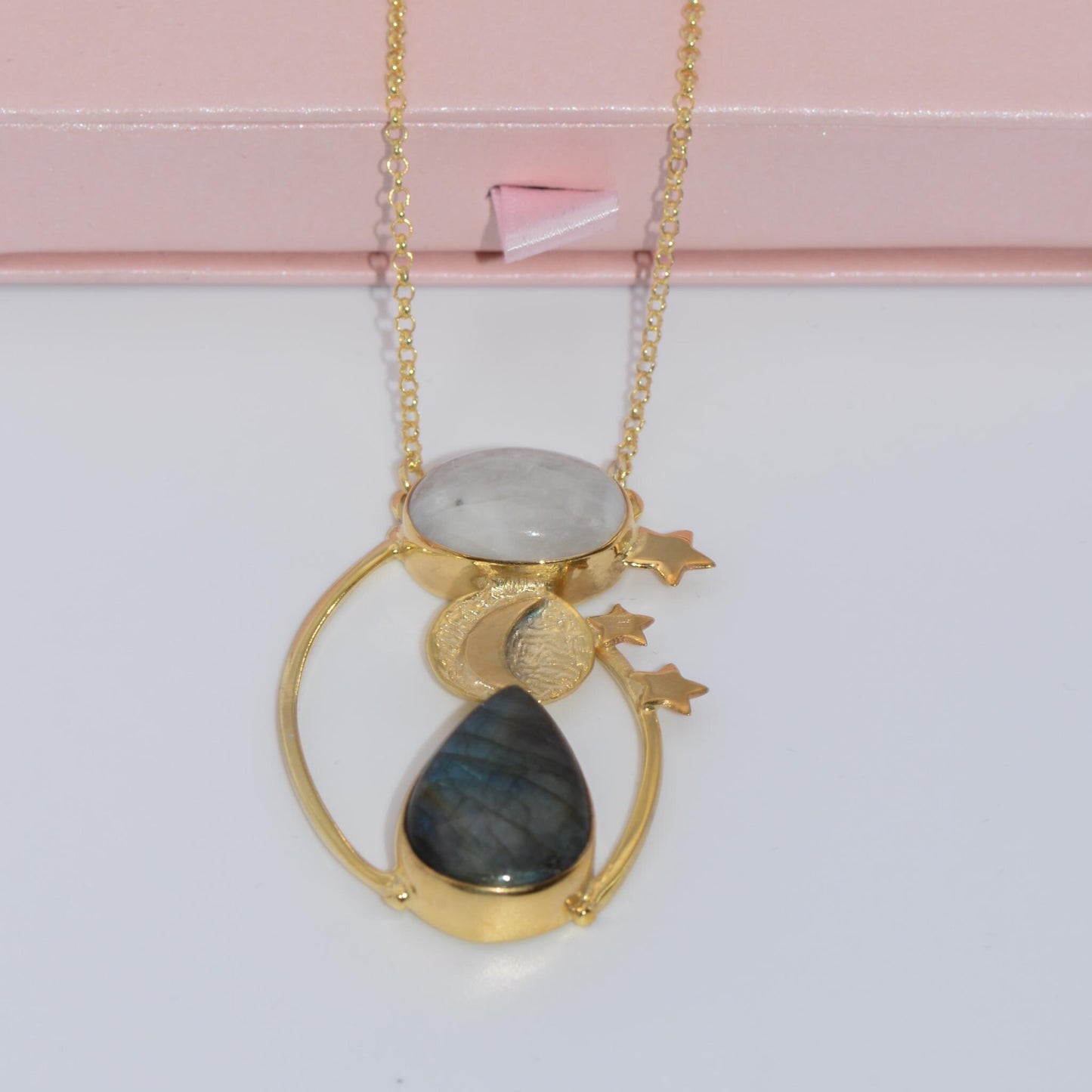 Day and Night Moonstone Silver Necklace with celestial design and gold accents, elegantly displayed on a delicate surface.