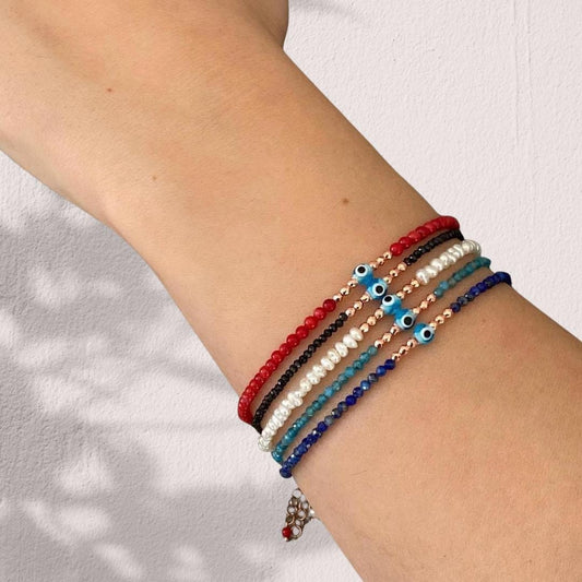 Stylish freshwater pearl bracelet featuring mini evil eye charm, a unique and elegant accessory for all occasions.