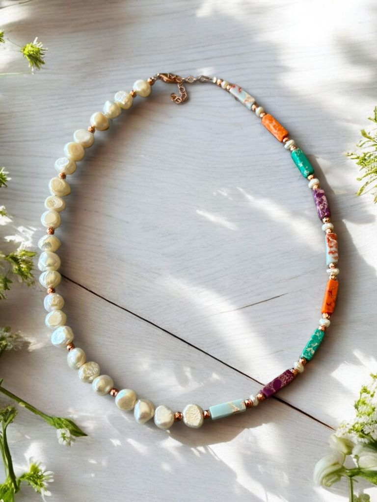 Liza Necklace with Variscite, Hematite, and Pearl in Rose Gold Plated Silver on white wooden background with floral accents.