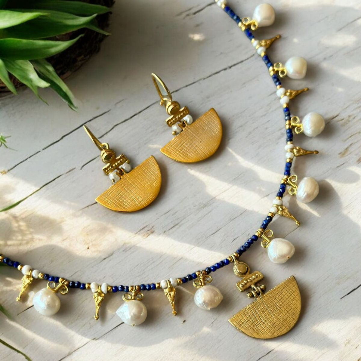 Selena Lapis Lazuli Necklace and Earrings Set - 14K Gold Plated, featuring gold half-moon pendants and white pearls on a white wooden surface.