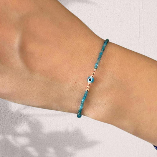 Elegant Apatite Gemstone Bracelet with a Mini Evil Eye Charm, worn as a stylish accessory perfect for any look.