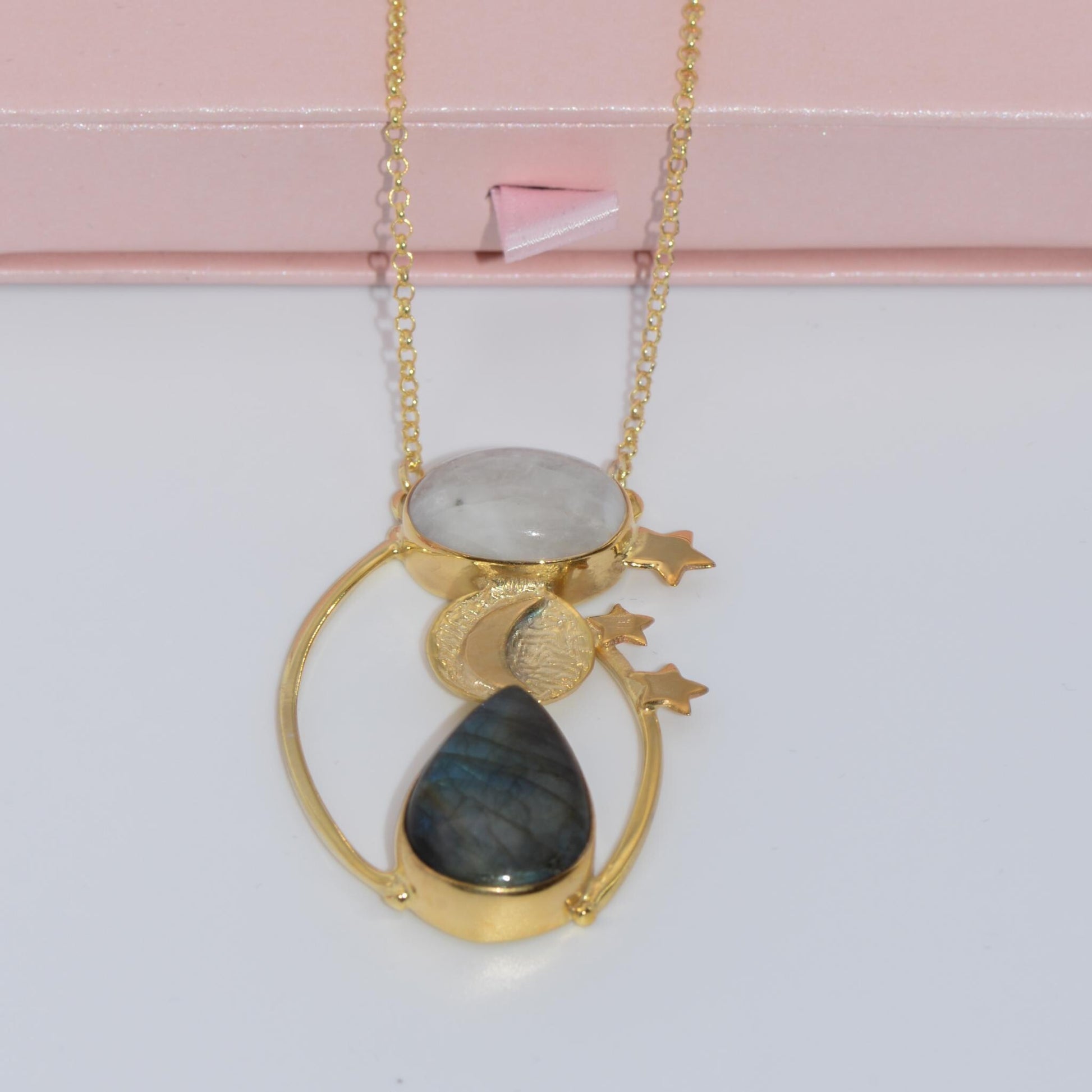 Day and Night Moonstone Silver Necklace with celestial design and gold accents, elegantly displayed on a delicate surface.