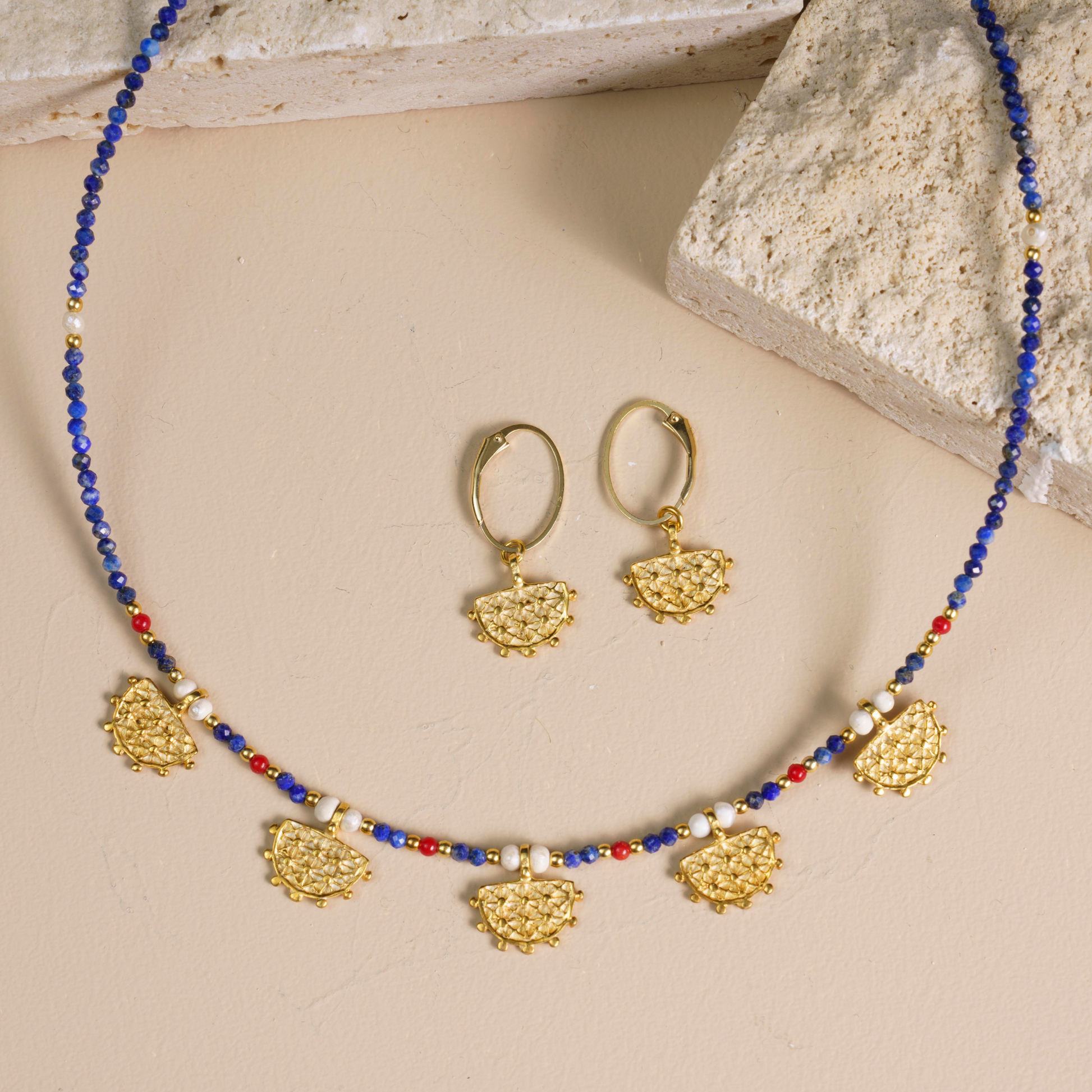 Gold-plated silver earrings featuring the Hittite sun symbol, photographed along a matching intricately beaded necklace.