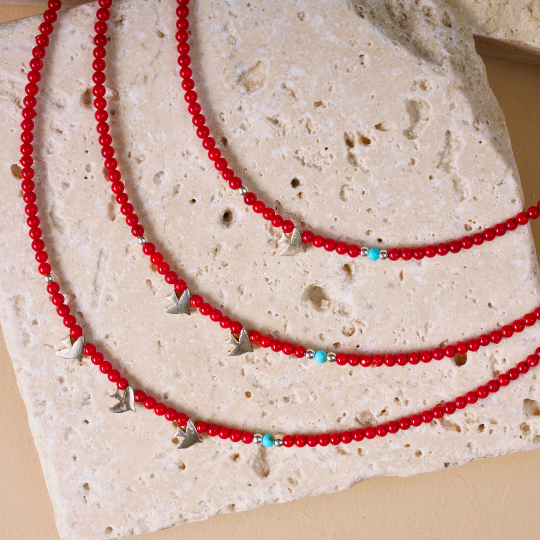Minimalist 925 Sterling Silver Bird Pendant Coral Gemstone Necklace on a textured stone background for elegant jewellery.