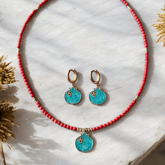 Nar Red Coral Gemstone Necklace and Earrings Set with turquoise pomegranate pendants on a light wooden background.