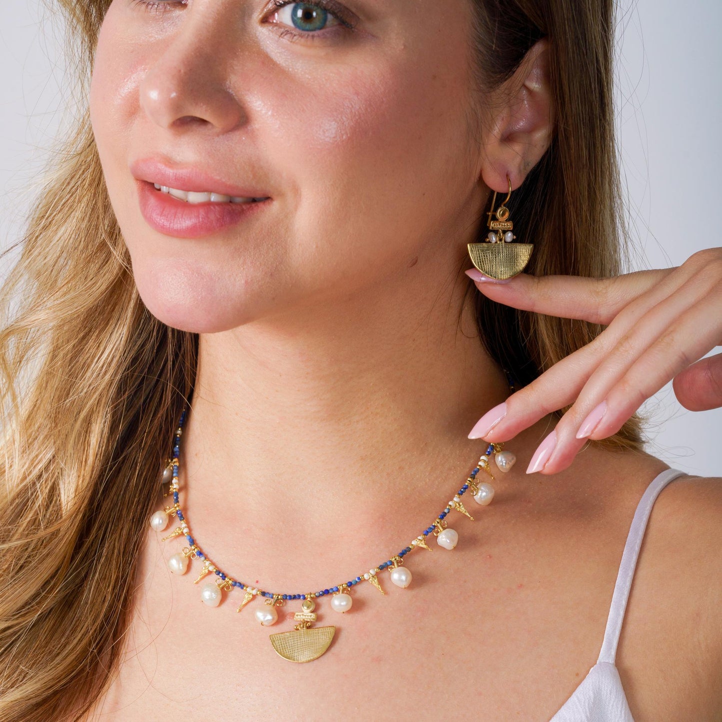 Model showcasing gold-plated Selena silver earrings and a matching pearl-detailed necklace, elegant and stylish.